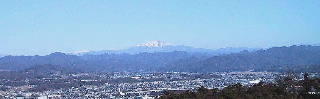 美濃加茂の町の向こうに御嶽山、左は乗鞍岳